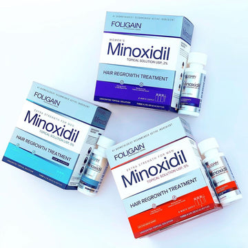 FOLIGAIN minoxidil boxes and bottles in orange, blue and purple packaging.