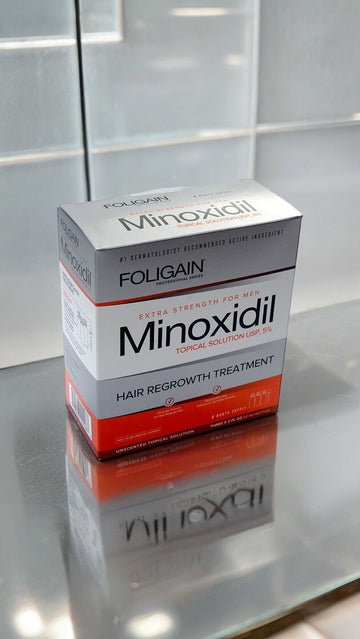 FOLIGAIN Minoxidil 5% Topical Solution box on a reflective surface.