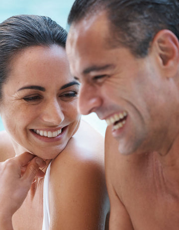 Smiling man and woman with wet hair.