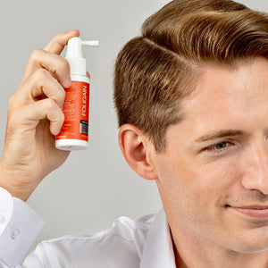 Man applying FOLIGAIN TRIOXIDIL topical treatment along his hairline